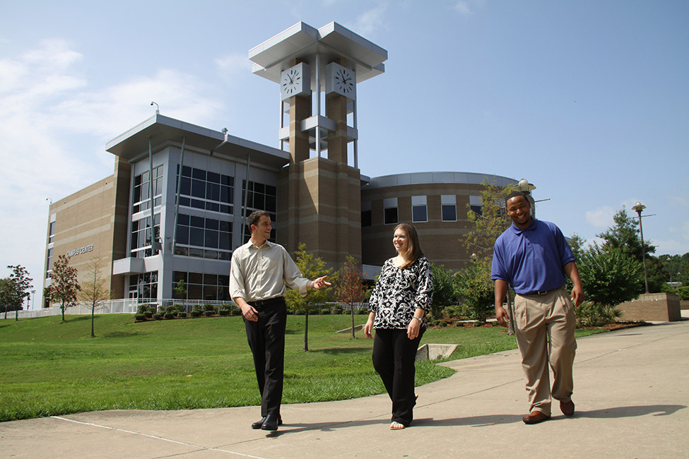 A group of faculty members walking around campus engaged in conversation