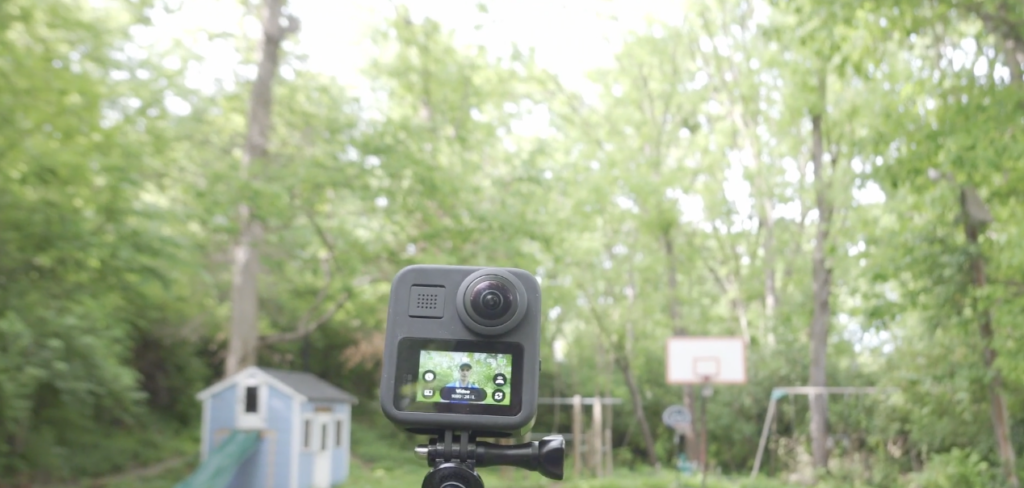 Image of a video camera on a tripod facing a large yard.
