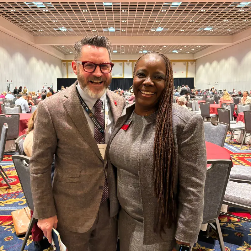 Jonathan Gyurko, PhD (ACUE President and Co-Founder) and Yolanda Watson Spiva, PhD (Complete College America President) posing in a large convention center hall