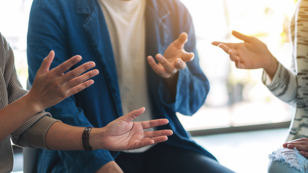 Close up image of three people's hands while in a conversation