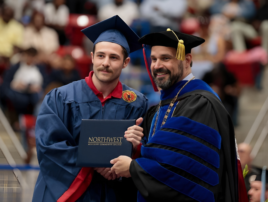 NWCC President Dr. Michael Heindl posing with a recent graduate at commencement.