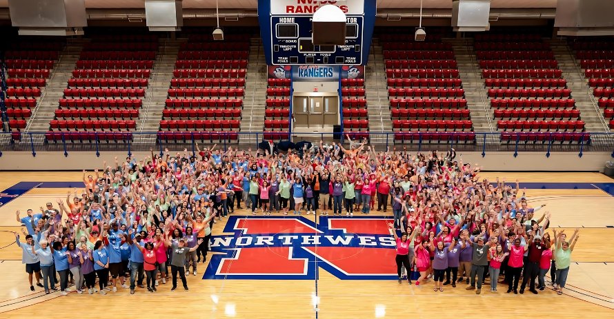 NWCC faculty standing in a "U" shape in a large gymnasium.