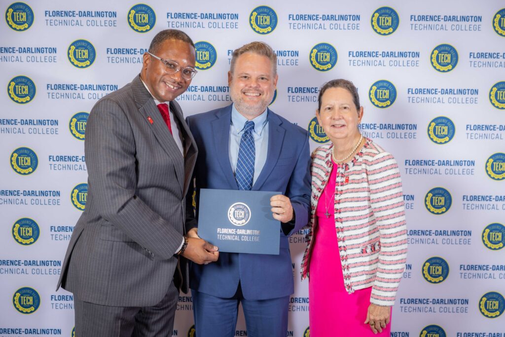 FDTC president posing with faculty during award ceremony
