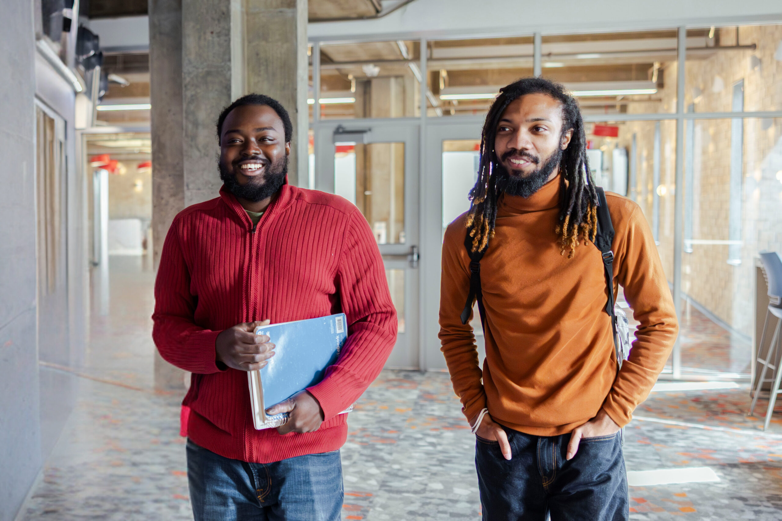 Two students walking down the hall at a university